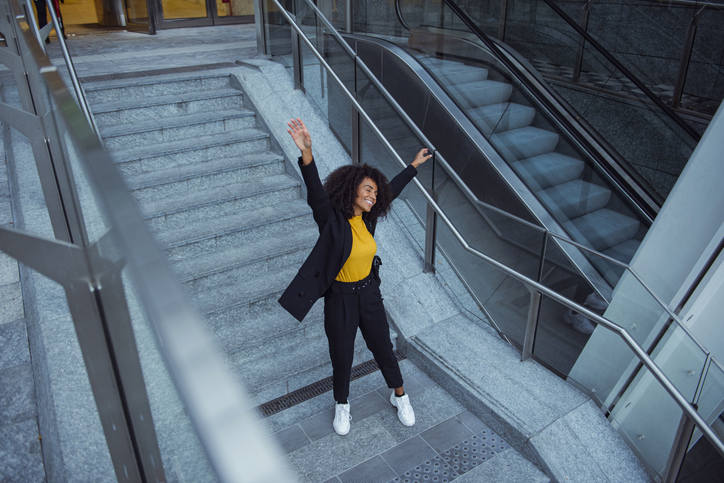 Joyful business woman celebrating outdoors
