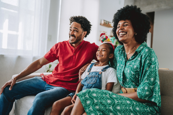 Family Sitting on the Sofa and Smiling During Christmas Season
